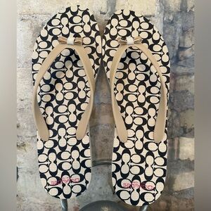 Coach Amel Signature C Thong Sandals in a black and beige colorway.